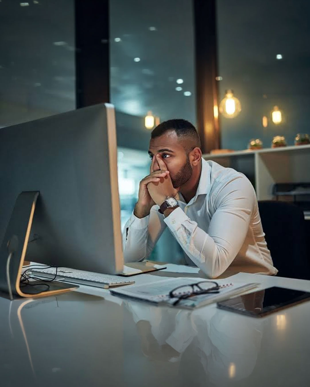 Small business owner looking stressed while staring at a computer screen — visual metaphor for hidden website costs and change orders